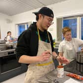 New charity kitchen set to support low income families through high cost of living period. Kids Kabin international volunteer Milo (left) helps children in the new site.