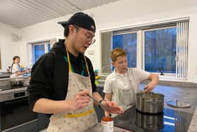 New charity kitchen set to support low income families through high cost of living period. Kids Kabin international volunteer Milo (left) helps children in the new site.