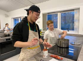 New charity kitchen set to support low income families through high cost of living period. Kids Kabin international volunteer Milo (left) helps children in the new site.