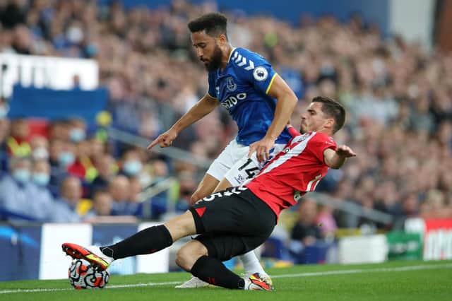 LIVERPOOL, ENGLAND - AUGUST 14: Andros Townsend of Everton is tackled by Romain Perraud of Southampton during the Premier League match between Everton and Southampton at Goodison Park on August 14, 2021 in Liverpool, England. (Photo by Ian MacNicol/Getty Images)