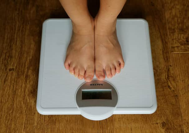 A young child is weighed on scales.