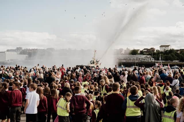 Crowds watch the Svitzer tug water jets at the unveiling of the Herring Girl on sculpture on the Fish Quay in September 2023.