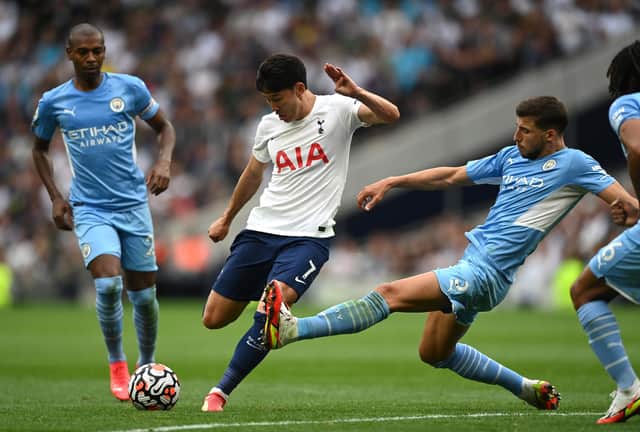 LONDON, ENGLAND - AUGUST 15:  Heung-Min Son of Tottenham Hotspur fires in a shot as Ruben Dias of Manchester City challenges during the Premier League match between Tottenham Hotspur and Manchester City at Tottenham Hotspur Stadium on August 15, 2021 in London, England. (Photo by Shaun Botterill/Getty Images)