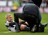 Newcastle United midfielder Bruno Guimaraes receives medical treatment against Fulham.