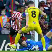 Preston North End's Freddie Woodman saves at the feet of Jewison Bennette.