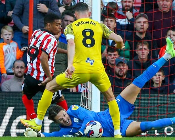 Preston North End's Freddie Woodman saves at the feet of Jewison Bennette.