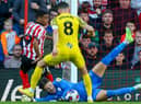 Preston North End's Freddie Woodman saves at the feet of Jewison Bennette.