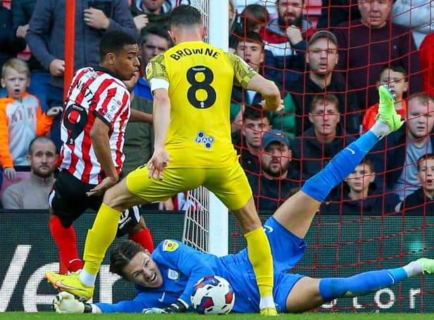 Preston North End's Freddie Woodman saves at the feet of Jewison Bennette.