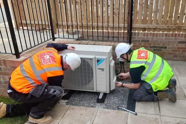 Members of the John N Dunn Group team working on an air source heat pump installation
