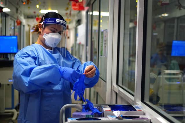 File photo dated 21/12/2021 of a nurse puts on PPE in a ward for Covid patients at King's College Hospital, in south east London. The Government has been told to "get a grip" of personal protective equipment (PPE) stocks and contracts, as it was disclosed more than half of suppliers who provided items through the VIP fast-track lane provided stock that was not suitable for use on the front line. Issue date: Wednesday March 30, 2022.