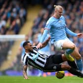 MANCHESTER, ENGLAND - MARCH 04: Erling Haaland of Manchester City is tackled by Jamaal Lascelles of Newcastle United during the Premier League match between Manchester City and Newcastle United at Etihad Stadium on March 04, 2023 in Manchester, England. (Photo by Laurence Griffiths/Getty Images)