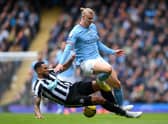 MANCHESTER, ENGLAND - MARCH 04: Erling Haaland of Manchester City is tackled by Jamaal Lascelles of Newcastle United during the Premier League match between Manchester City and Newcastle United at Etihad Stadium on March 04, 2023 in Manchester, England. (Photo by Laurence Griffiths/Getty Images)