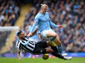 MANCHESTER, ENGLAND - MARCH 04: Erling Haaland of Manchester City is tackled by Jamaal Lascelles of Newcastle United during the Premier League match between Manchester City and Newcastle United at Etihad Stadium on March 04, 2023 in Manchester, England. (Photo by Laurence Griffiths/Getty Images)