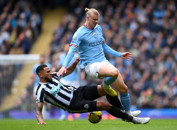 MANCHESTER, ENGLAND - MARCH 04: Erling Haaland of Manchester City is tackled by Jamaal Lascelles of Newcastle United during the Premier League match between Manchester City and Newcastle United at Etihad Stadium on March 04, 2023 in Manchester, England. (Photo by Laurence Griffiths/Getty Images)