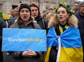 People hold placards during a rally in support of Ukraine, in near Downing Street on Whitehall in central London on March 13, 2022, following the invasion of the country by Russia. - Stung by criticism of its lacklustre approach to refugees fleeing Russia's invasion of Ukraine, the UK on Sunday unveiled a new scheme to allow them to stay with Britons for up to three years. (Photo by Niklas HALLE'N / AFP) (Photo by NIKLAS HALLE'N/AFP via Getty Images)