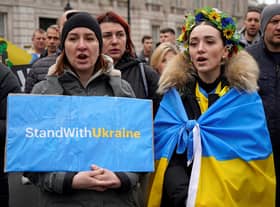 People hold placards during a rally in support of Ukraine, in near Downing Street on Whitehall in central London on March 13, 2022, following the invasion of the country by Russia. - Stung by criticism of its lacklustre approach to refugees fleeing Russia's invasion of Ukraine, the UK on Sunday unveiled a new scheme to allow them to stay with Britons for up to three years. (Photo by Niklas HALLE'N / AFP) (Photo by NIKLAS HALLE'N/AFP via Getty Images)