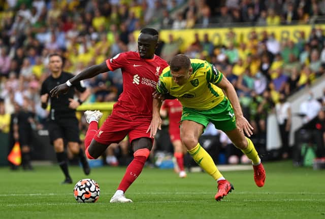 NORWICH, ENGLAND - AUGUST 14:  Sadio Mane of Liverpool is challenged by Ben Gibson of Norwich City during the Premier League match between Norwich City  and  Liverpool at Carrow Road on August 14, 2021 in Norwich, England. (Photo by Shaun Botterill/Getty Images)
