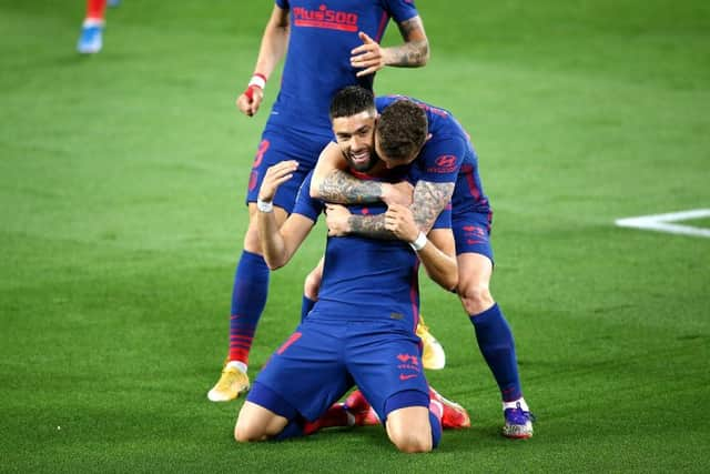 Yannick Carrasco of Atletico de Madrid celebrates with Kieran Trippier after scoring their side's first goal during the La Liga Santander match between Real Betis and Atletico de Madrid at Estadio Benito Villamarin on April 11, 2021 in Seville, Spain. Sporting stadiums around Spain remain under strict restrictions due to the Coronavirus Pandemic as Government social distancing laws prohibit fans inside venues resulting in games being played behind closed doors. (Photo by Fran Santiago/Getty Images)