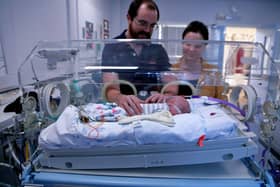 Parents at their baby's side, in hospital.