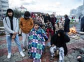 Earthquake survivors sit around a fire in Iskenderun Turkey