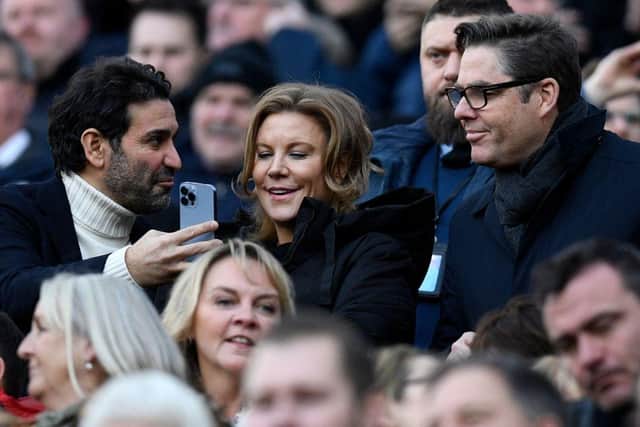 Newcastle United's owners Amanda Staveley (C) looks at her husband Mehrdad Ghodoussi's (L) phone, ahead of the English Premier League football match between Newcastle United and Fulham at St James' Park in Newcastle-upon-Tyne, north-east England on January 15, 2023. (Photo by OLI SCARFF/AFP via Getty Images)