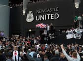 Newcastle supporters celebrate after Mike Ashley sold the club in October 2021. (Photo by -/AFP via Getty Images)