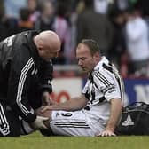 Derek Wright helps Alan Shearer at the Stadium of Light in 2006.