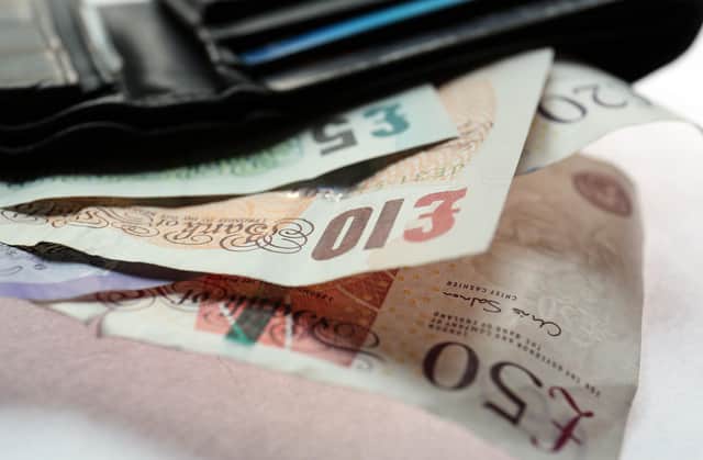 Stock picture Fifty, Twenty, Ten, and Five pound notes in a wallet.